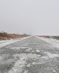 Slushy byroad at Rannie Road near the Grant Narrows Regional Park and Pitt River Dike during a snowy winter season in Pitt Meadows, British Columbia, Canada.