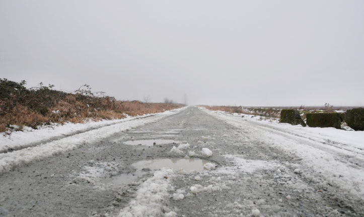 Slushy byroad at Rannie Road near the Grant Narrows Regional Park and Pitt River Dike during a snowy winter season in Pitt Meadows, British Columbia, Canada.